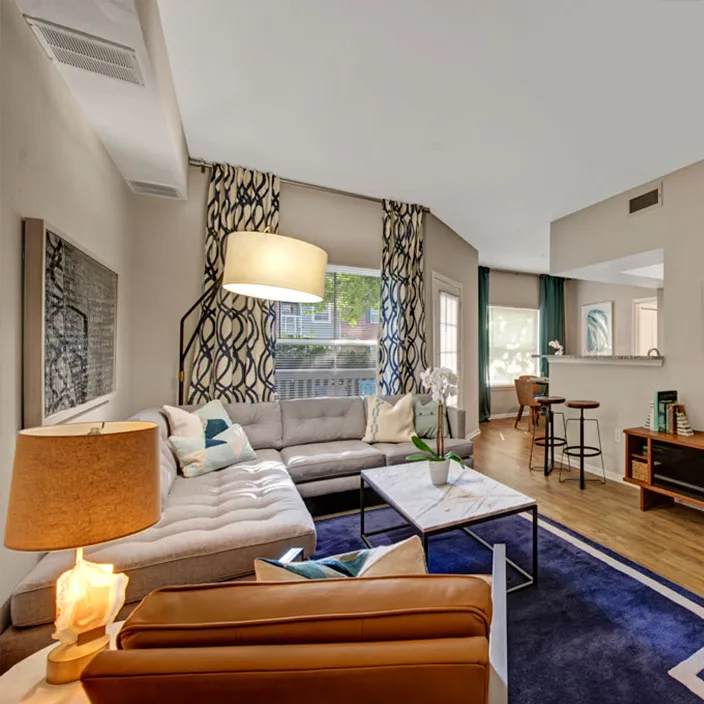 Spacious open-plan living room with stylish decor, wooden flooring, and contemporary lighting fixtures