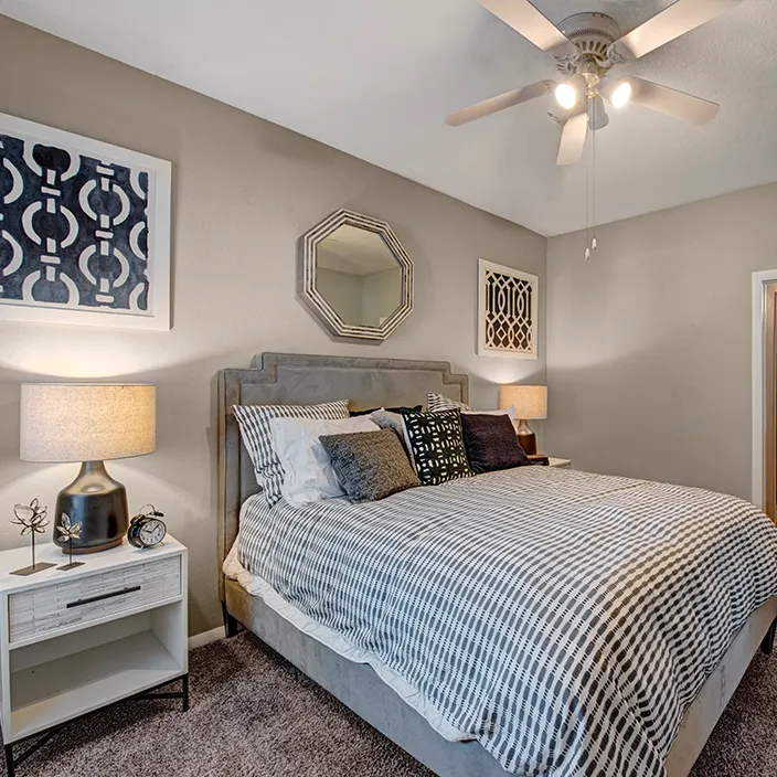 Inviting bedroom with plush bedding, patterned bed spread, and cozy bedside lighting