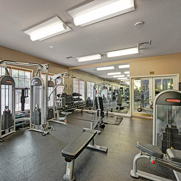 Spacious gym area with weight machines, mirrors, and a variety of fitness equipment